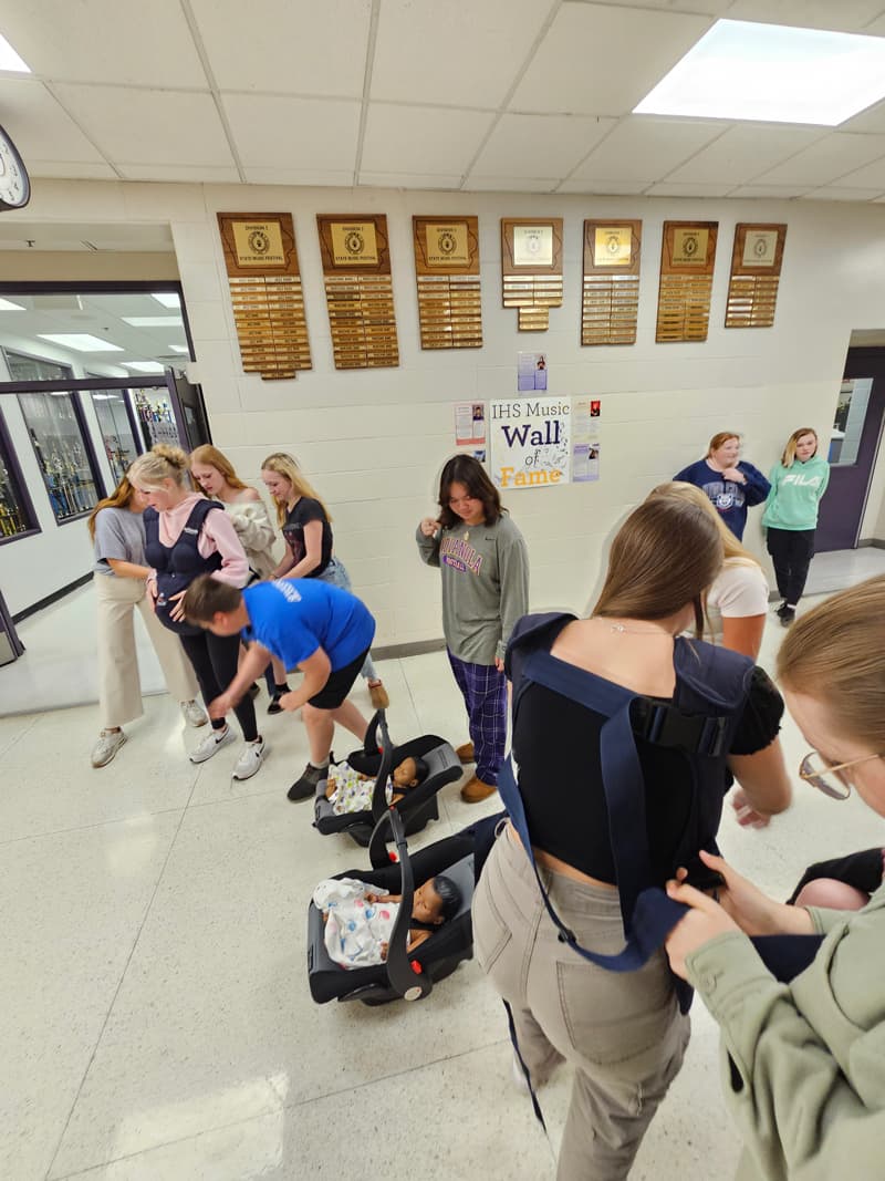 20240925_140631-min Students in hallway with baby doll in carriers
