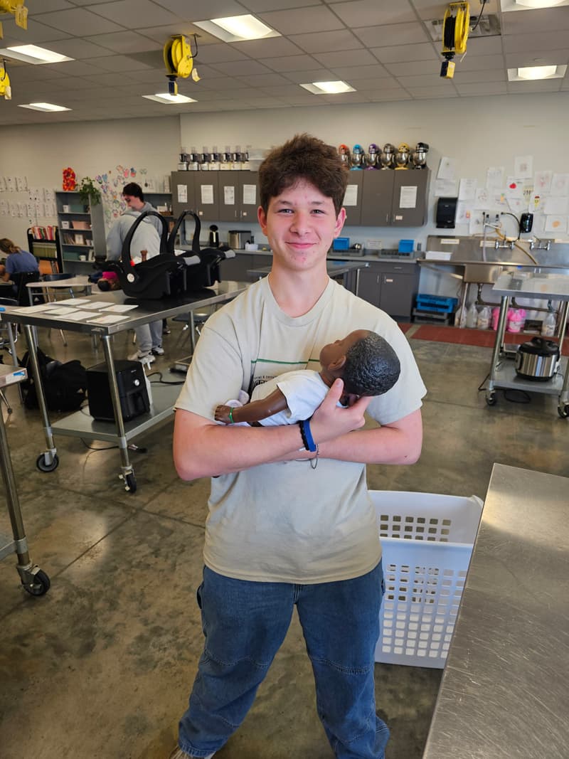 20240926_091312-min Boy holding baby doll in kitchen