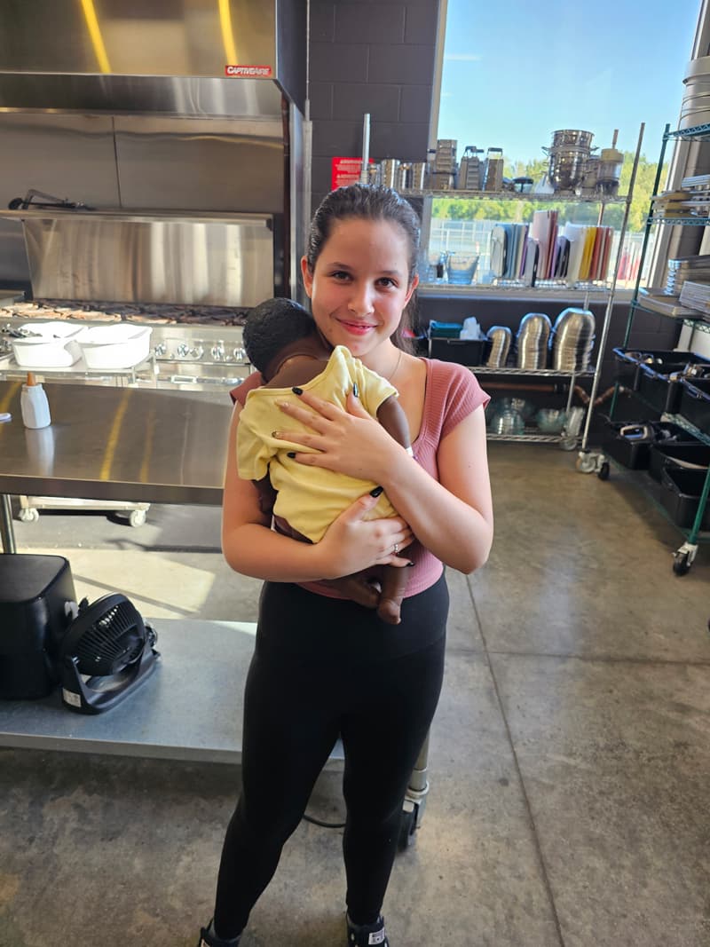 20240926_091346-min Girl holding baby doll in kitchen