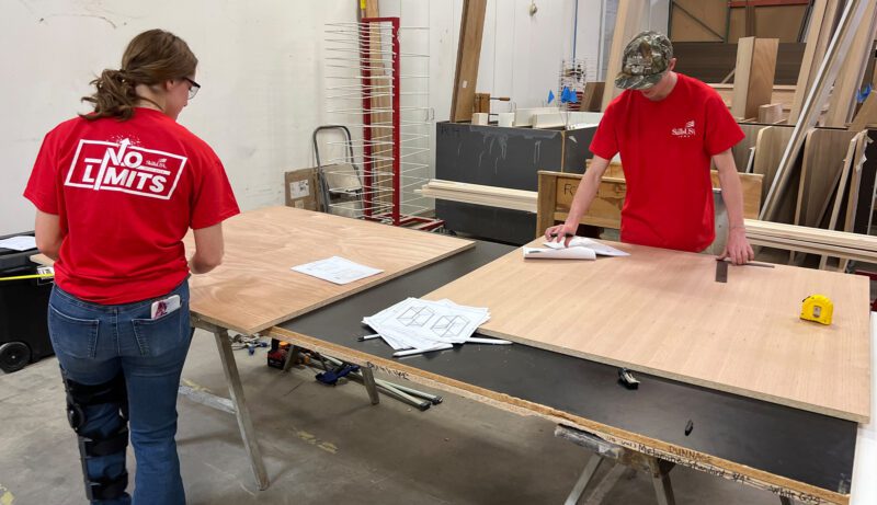 Students with sheets of wood building