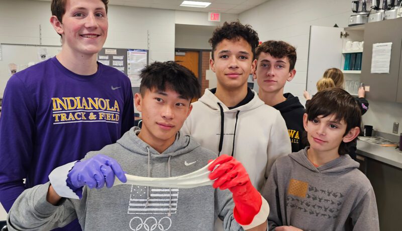 ICT-2 Group of students cooking with one holding dough