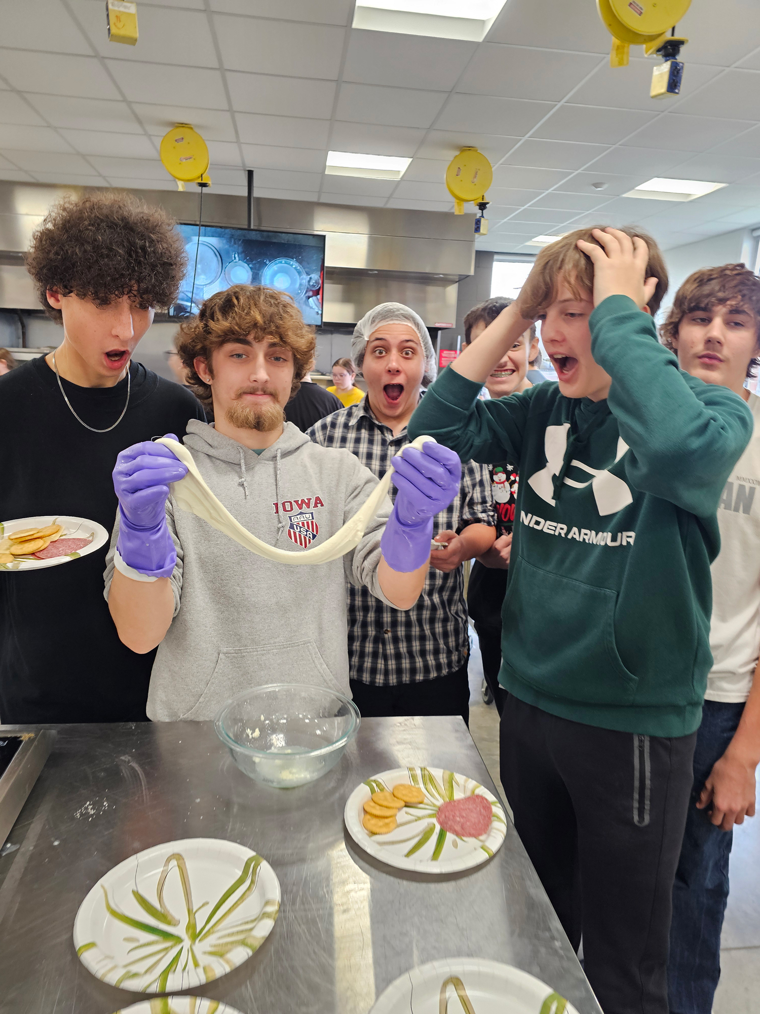 foods Group of students cooking one holding dough